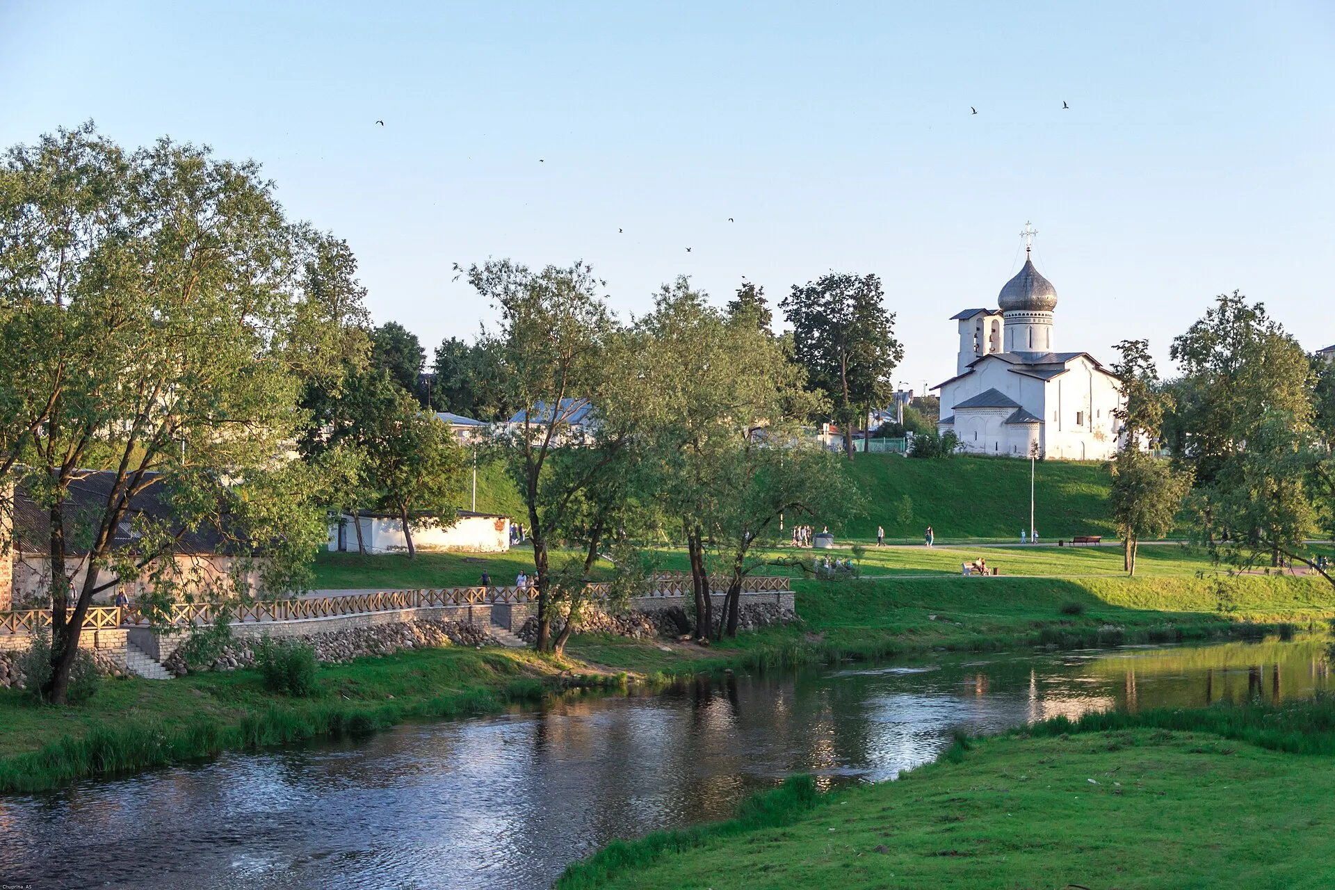 Парк Куопио на берегу реки Псковы летним вечером, на холме белая церковь