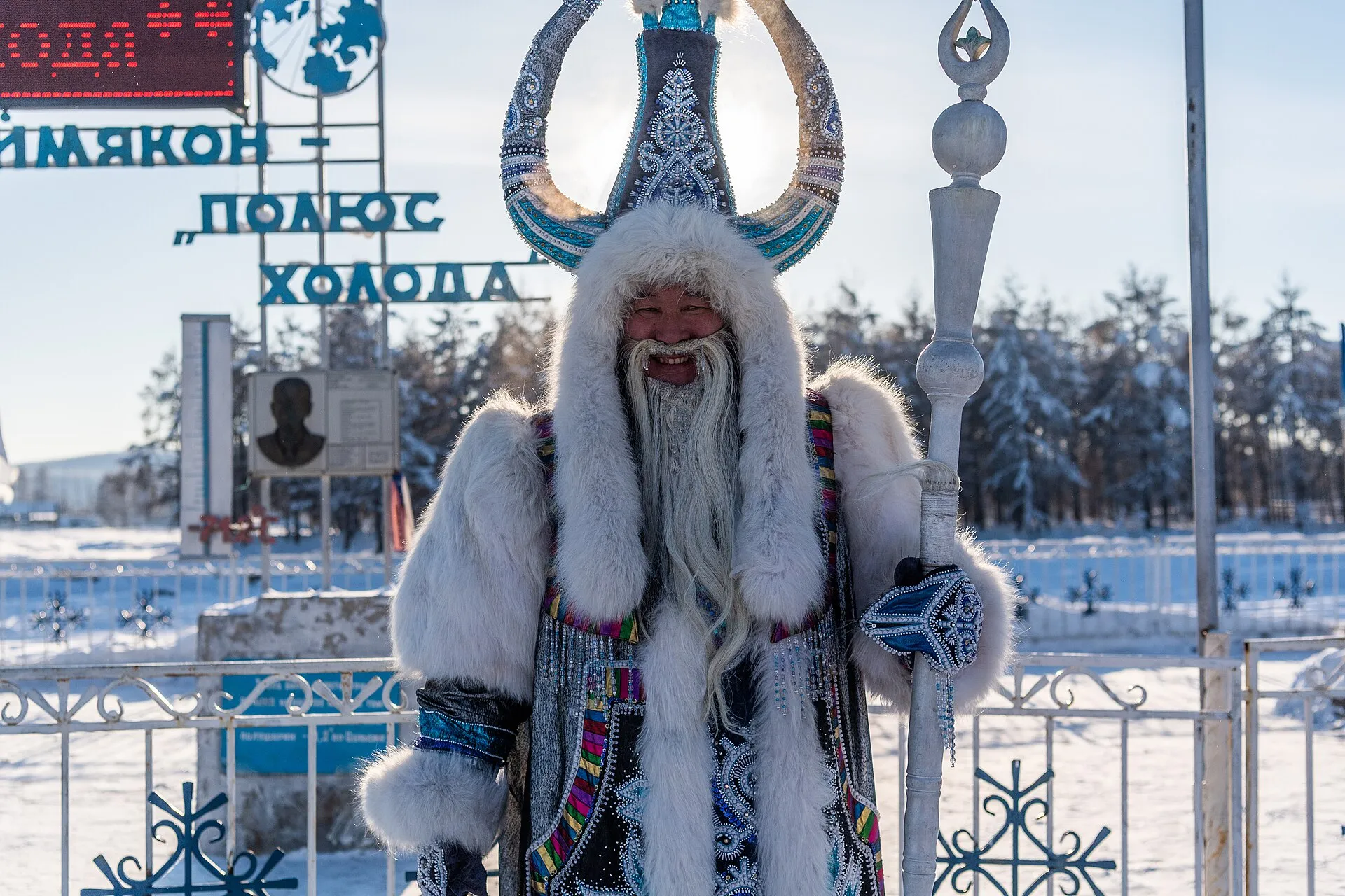 Чысхаан, якутский властелин холода, в меховом костюме и высоком головном уборе у стелы «Оймякон — полюс холода»